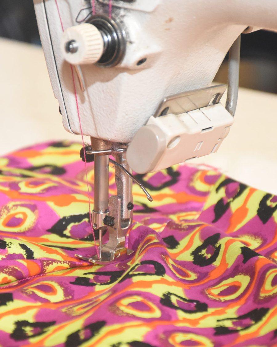 A machinist finishing a garment at an industrial machine