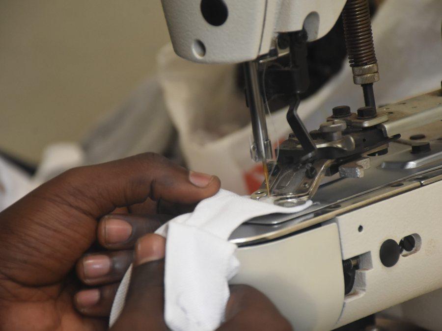 A machinist guiding fabric under the needle