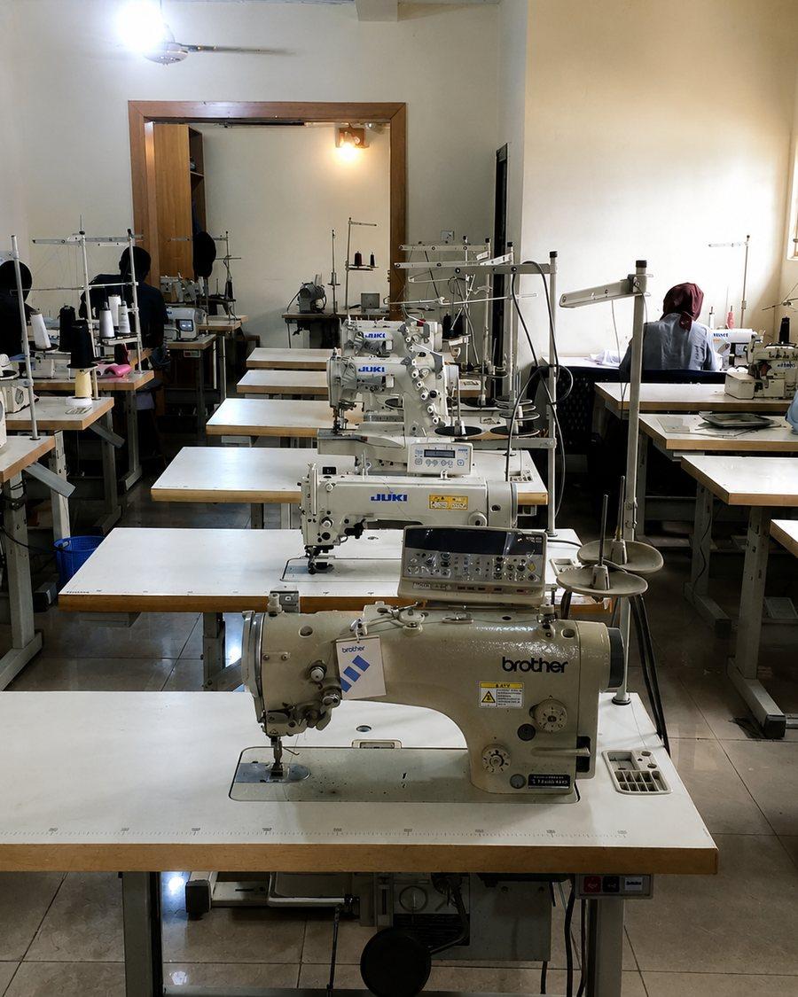 Rows of industrial sewing machines on the Udofe production floor